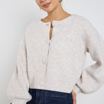 model wears a oat cropped cardigan with blue wide leg jean