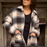 model wears a black and white check jacket