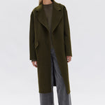 model wears a green wool coat