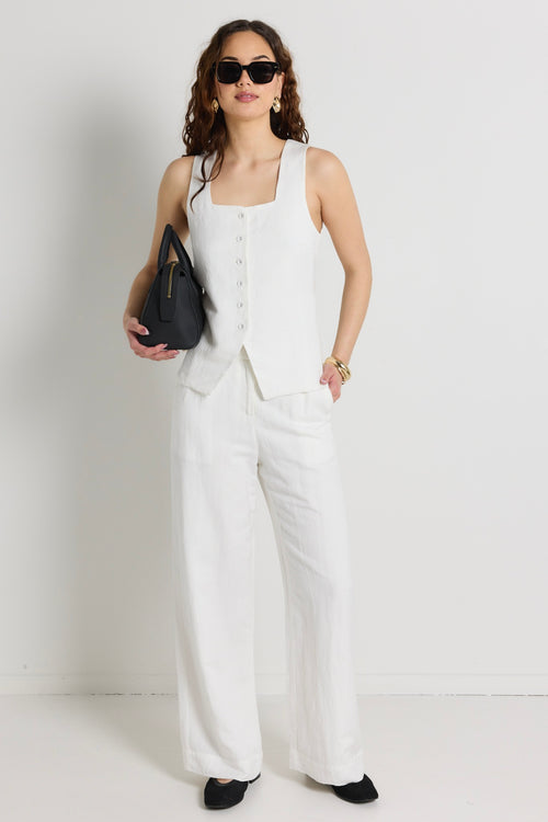 model wears a white linen vest