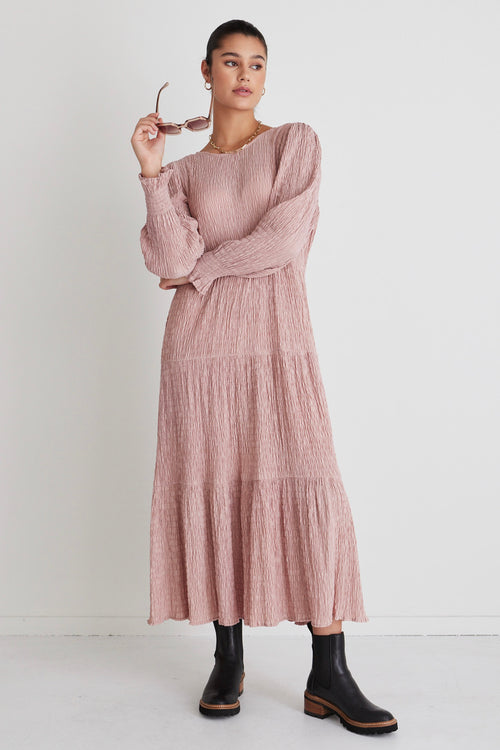 model wears a pink long sleeve dress