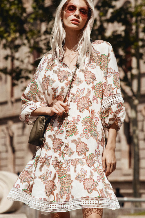 model wears cream floral mini dress