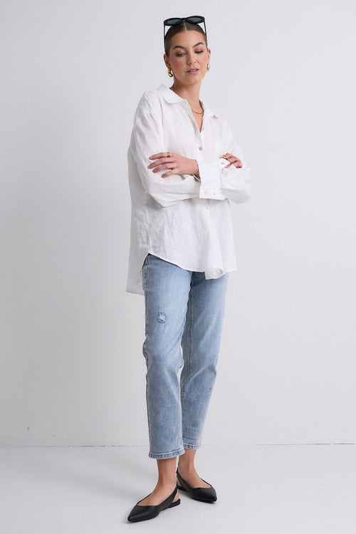 Model wears blue jeans with a white shirt 