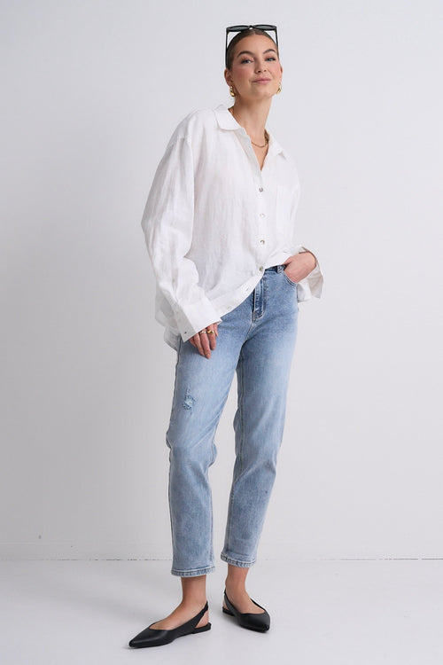 Model wears blue jeans with a white shirt 