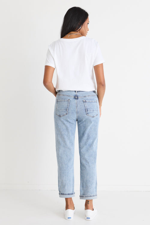 Model wears blue jeans with a white shirt 