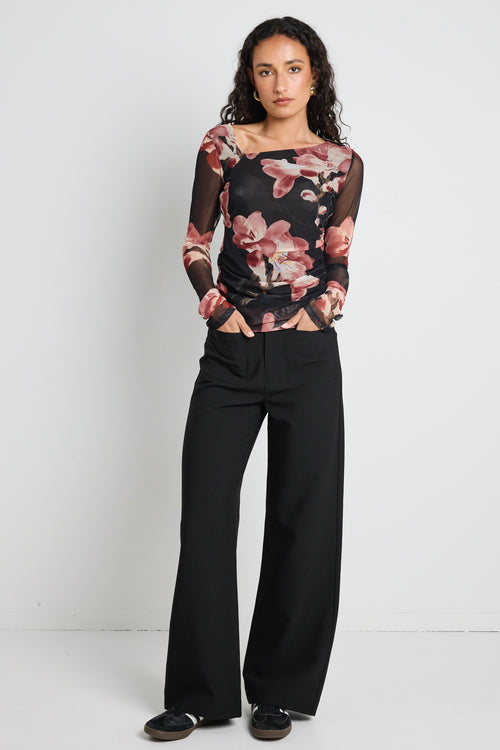 Model wears a mesh floral printed asymmetrical blush top 