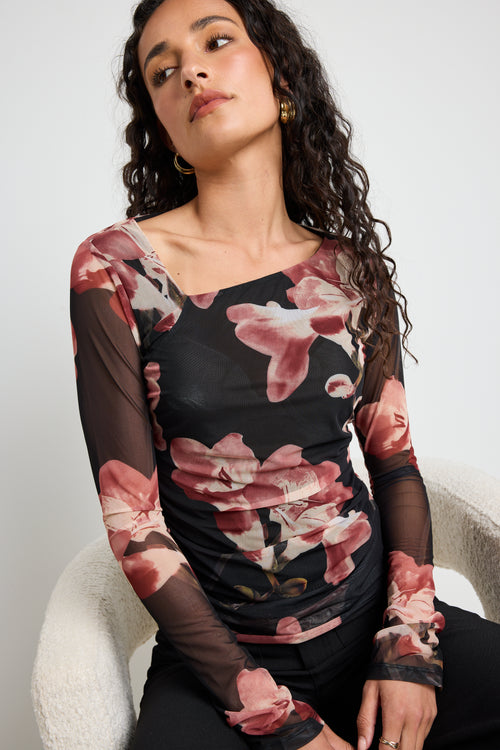 Model wears a mesh floral printed asymmetrical blush top 