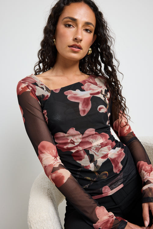 Model wears a mesh floral printed asymmetrical blush top 