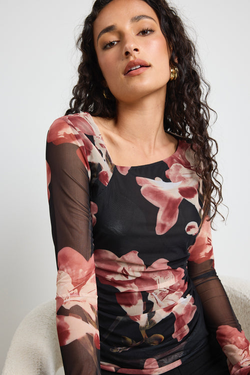 Model wears a mesh floral printed asymmetrical blush top 