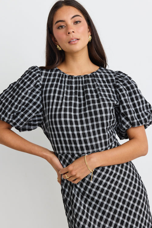 model wears a black and white check maxi dress