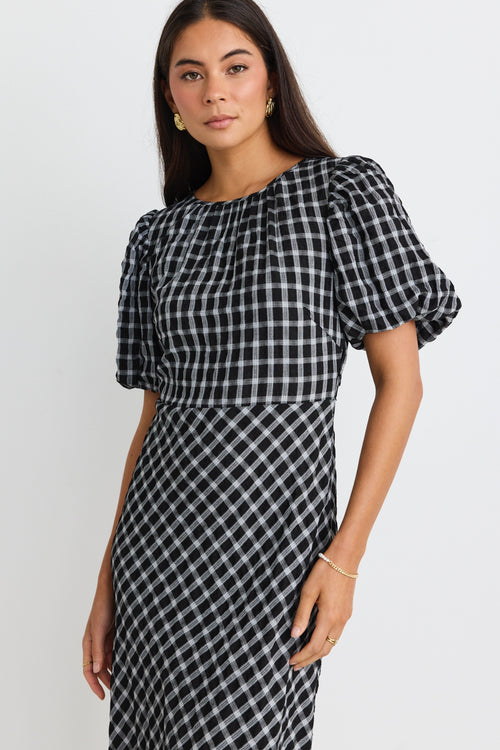 model wears a black and white check maxi dress