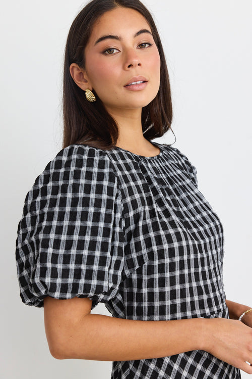 model wears a black and white check maxi dress