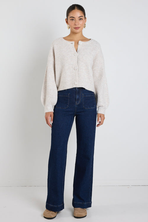 model wears a oat cropped cardigan with blue wide leg jean