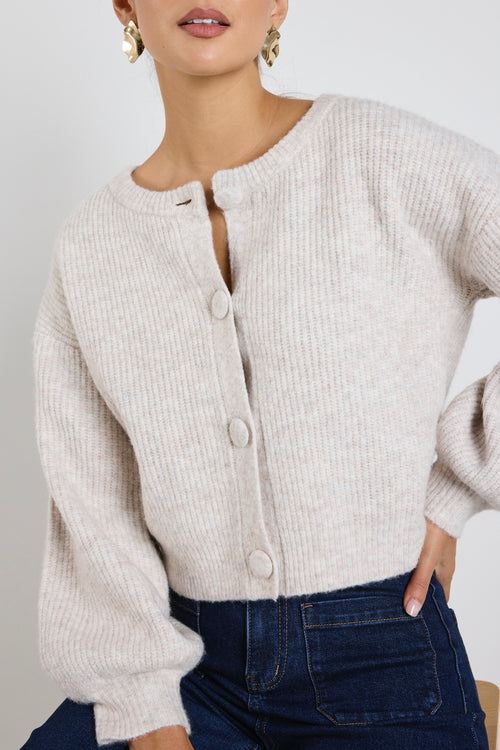 model wears a oat cropped cardigan with blue wide leg jean