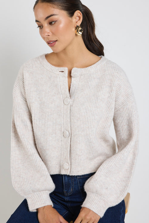 model wears a oat cropped cardigan with blue wide leg jean