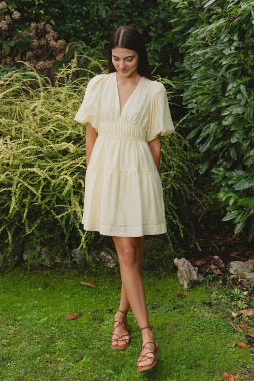 model wears a yellow mini dress