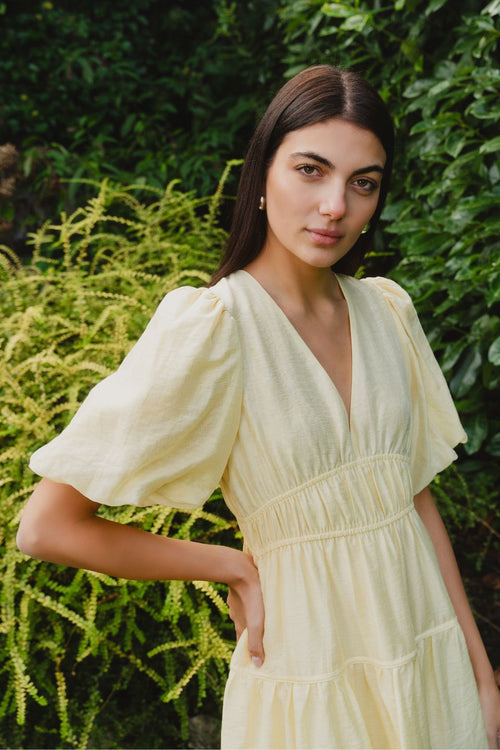 model wears a yellow mini dress