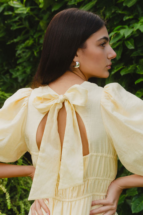 model wears a yellow mini dress