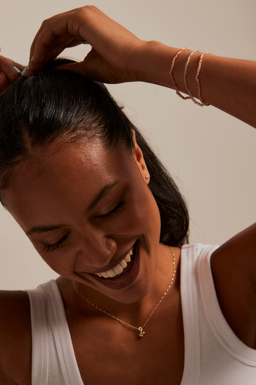 model wearing peach beaded set of bracelets