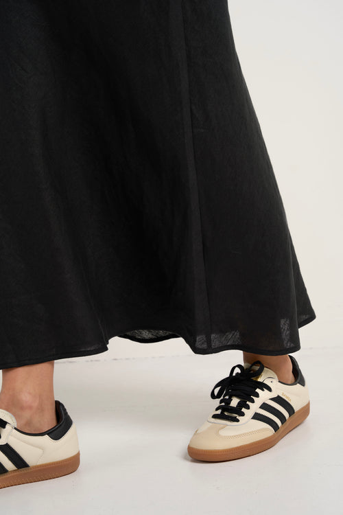 model wears a black linen midi skirt