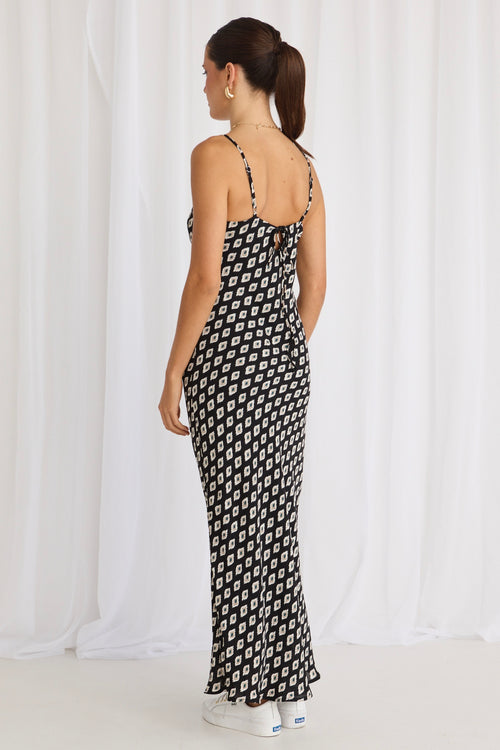 model wears a black print bias maxi dress