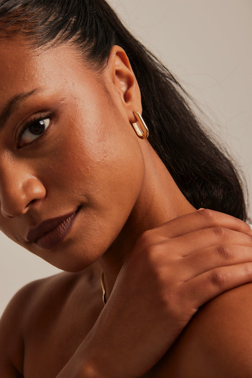 model wearing Chunky Oval Gold Hoop Earrings