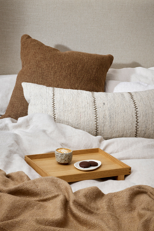 brown textured cushion on bed