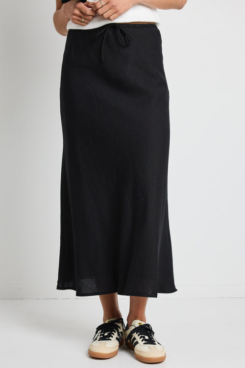 model wears a black linen maxi skirt