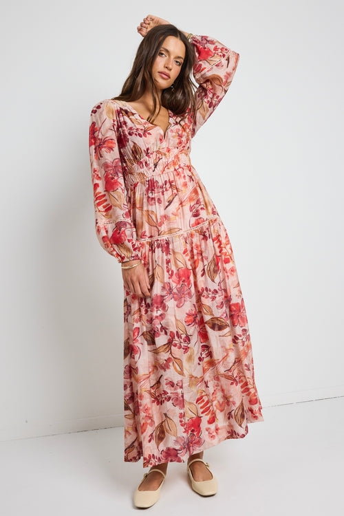 model wears a blush floral tiered dress