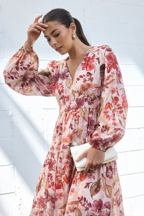 model wears a blush floral tiered dress