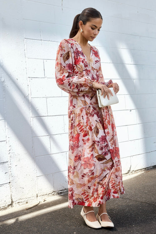 model wears a blush floral tiered dress