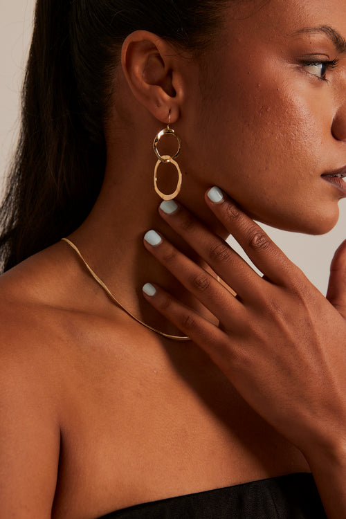 model wearing double link gold earrings