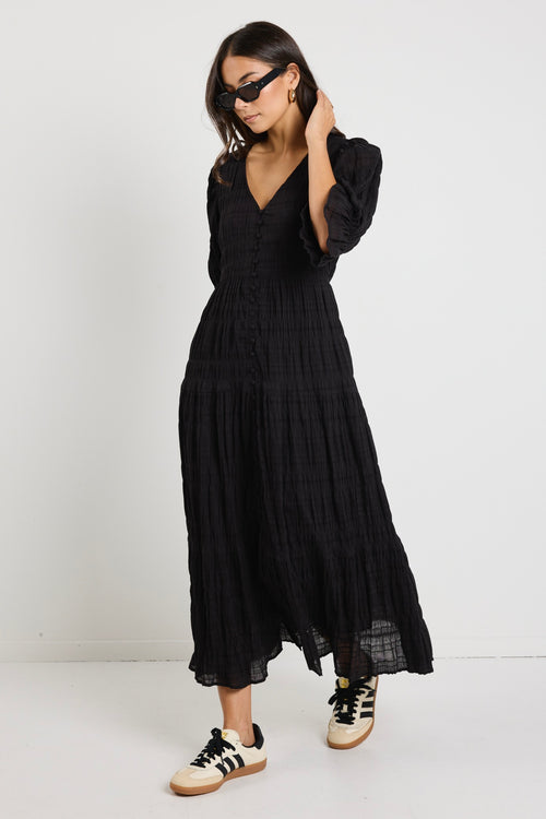 model wears a black maxi dress