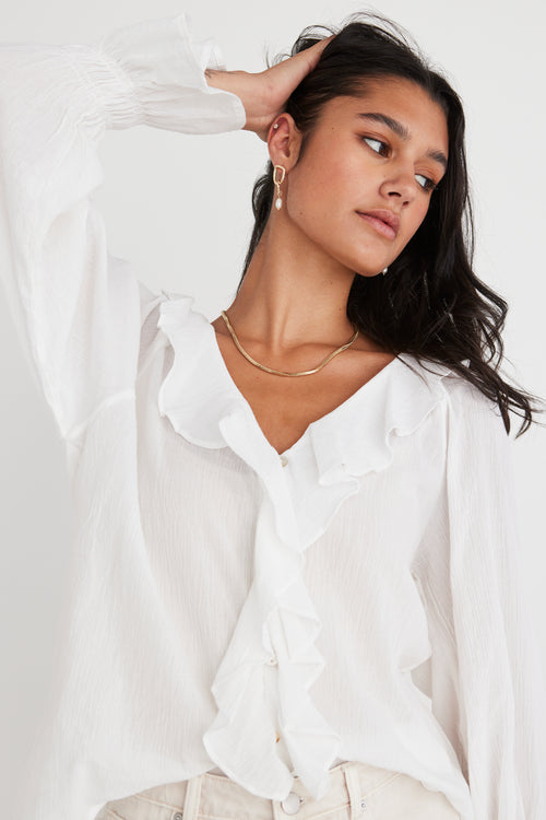 model wears a white blouse