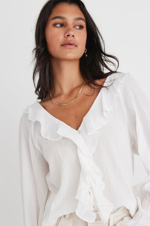 model wears a white blouse