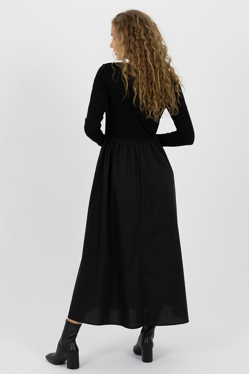 model wears a black long sleeve dress