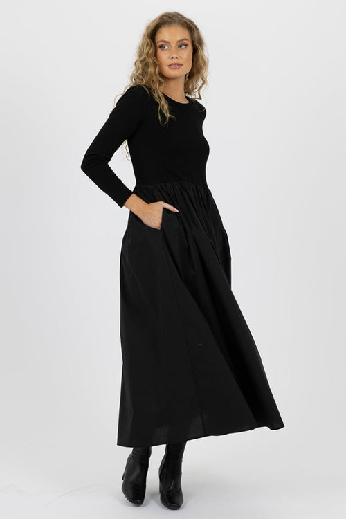 model wears a black long sleeve dress