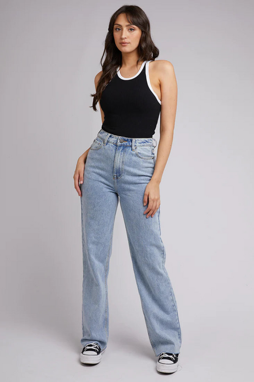 model in black tank with white lining and blue jeans