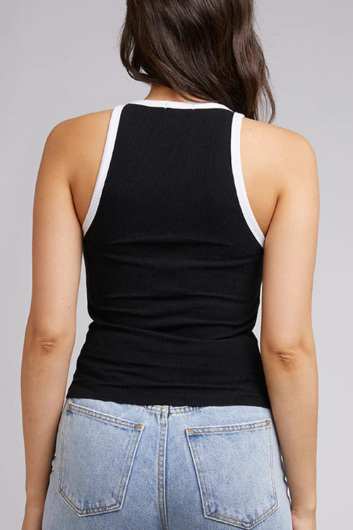 model in black tank with white lining and blue jeans