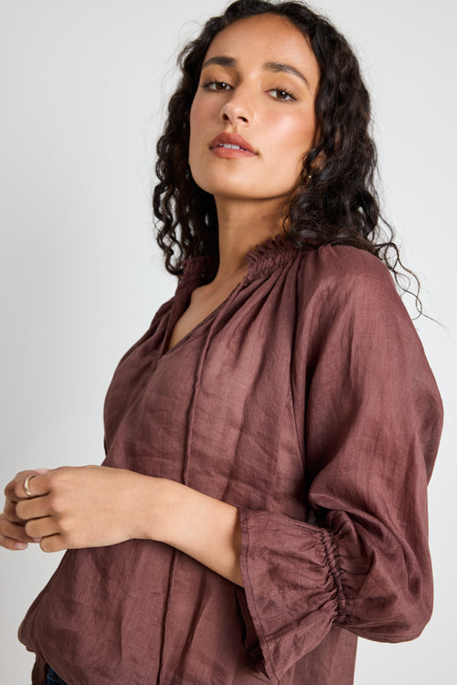 model wears a brown linen top with jeans