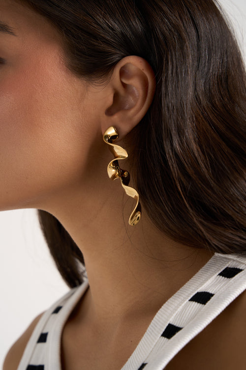 model wears gold earrings