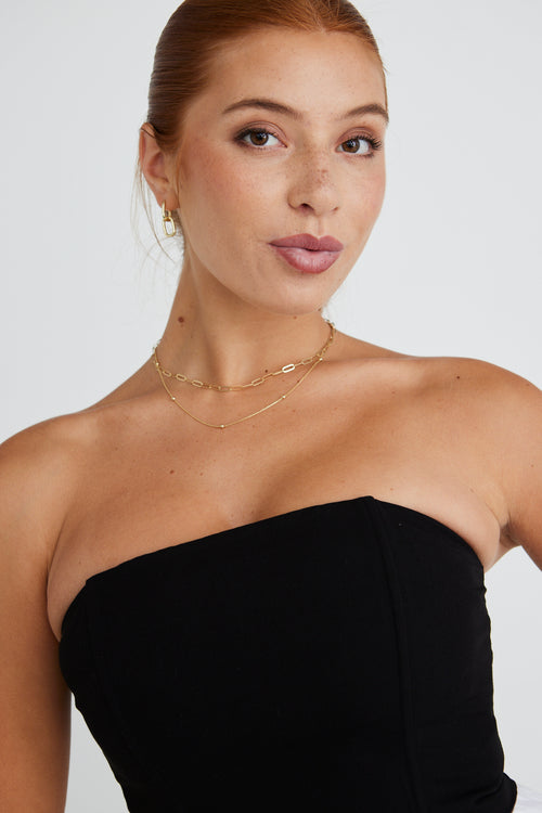 model wears a strapless black top