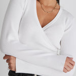 model wears a white long sleeve top