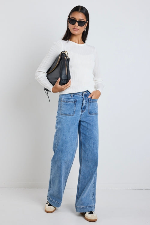 Model wears blue high waisted jeans 