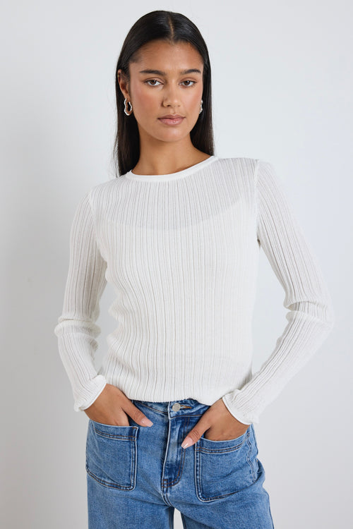 model wears a white long sleeve top 