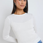 model wears a white long sleeve top 