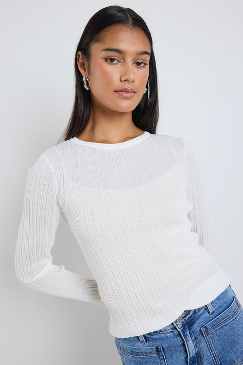 model wears a white long sleeve top 