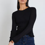 Model wears black long sleeve top with dark blue jeans