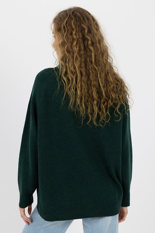 model wears a green knit jumper