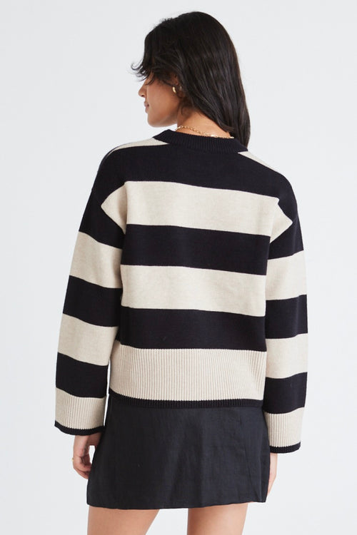 model wears a beige and black stripe knit